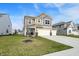 Two-story tan home with a three-car garage and a manicured front lawn at 8583 Strabet Dr, Pendleton, IN 46064