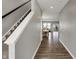 Hallway with wood floors leading to dining room and staircase with white railing at 8583 Strabet Dr, Pendleton, IN 46064