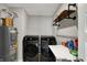 Modern laundry room features front load washer and dryer with decorative shelving and utility sink at 8583 Strabet Dr, Pendleton, IN 46064