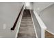 Carpeted stairway with a wooden handrail, offering easy access between levels of the home at 8583 Strabet Dr, Pendleton, IN 46064