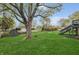 This large backyard features mature trees, a large lawn, an outbuilding, and a fire pit at 9034 Caminito Ct, Indianapolis, IN 46234