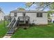The backyard features a well-maintained lawn, a deck with stairs, and mature trees, creating a serene outdoor space at 9034 Caminito Ct, Indianapolis, IN 46234