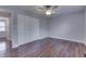 Comfortable bedroom with hardwood floors, a ceiling fan, closet, and access to the hall at 9034 Caminito Ct, Indianapolis, IN 46234