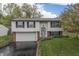 Charming split-level home featuring a well-manicured lawn, attached garage and lovely landscaping at 9034 Caminito Ct, Indianapolis, IN 46234