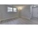 This living room features modern gray plank flooring, neutral paint, and ample natural light from the large window at 9034 Caminito Ct, Indianapolis, IN 46234