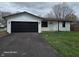 Charming single-story home with a black garage door, white brick, and a well-maintained front yard at 909 Pearl St, Cicero, IN 46034