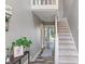 Inviting foyer with a staircase, modern decor, and hardwood floors, leading to a bright living space at 9658 Highgate N Cir, Indianapolis, IN 46250