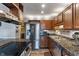 Well-lit kitchen featuring stainless steel appliances, granite countertops, and wood cabinets at 9658 Highgate N Cir, Indianapolis, IN 46250