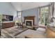 Cozy living room featuring a fireplace, comfortable sofa, and plenty of natural light from large windows at 9658 Highgate N Cir, Indianapolis, IN 46250