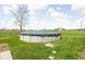 View of an above-ground pool with a covered top and a barn in the background, surrounded by green grass at 10239 Wilson Rd, Brownsburg, IN 46112