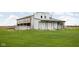 Exterior view of a white wooden barn in need of repair, set against a background of a green field at 10239 Wilson Rd, Brownsburg, IN 46112