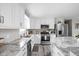 Contemporary kitchen showcasing stainless steel appliances, granite countertops, and bright white cabinetry at 10239 Wilson Rd, Brownsburg, IN 46112