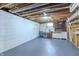 Spacious basement featuring painted concrete walls and floors, exposed ductwork, and built-in storage at 10586 W School Pkwy, Carmel, IN 46280