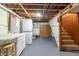 Basement with laundry area, utility sink, and stairs leading to the upper level at 10586 W School Pkwy, Carmel, IN 46280