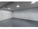 Spacious unfinished basement with painted concrete floor and white concrete walls at 10586 W School Pkwy, Carmel, IN 46280