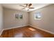 Bedroom featuring a ceiling fan, hardwood floors, neutral walls, and two windows at 10586 W School Pkwy, Carmel, IN 46280