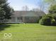Brick house backyard featuring a deck and a spacious, well-maintained lawn at 1080 W Wildflower Ct, Mooresville, IN 46158