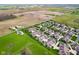 An aerial view showing a well-maintained community surrounded by farmland and mature trees at 1098 Extraordinary Trl, Greenfield, IN 46140