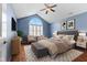 Staged primary bedroom with sitting area, large window, and hardwood floors at 1098 Extraordinary Trl, Greenfield, IN 46140