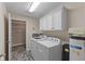 Bright laundry room with modern washer and dryer, overhead cabinets, and closet at 1098 Extraordinary Trl, Greenfield, IN 46140