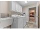 Bright laundry room with modern washer and dryer, cabinets, sink, and backyard access at 1098 Extraordinary Trl, Greenfield, IN 46140