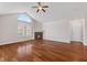 Bright living room features hardwood floors, a fireplace, and high ceilings with a fan and arched window at 1098 Extraordinary Trl, Greenfield, IN 46140