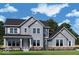 Charming two-story home featuring gray siding, dark roof, manicured lawn, and stylish architectural details at 11338 Briargate Dr, Fishers, IN 46055