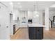 Bright kitchen features white cabinetry, stainless steel appliances, and a center island with pendant lighting at 11338 Briargate Dr, Fishers, IN 46055