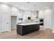 Modern kitchen featuring a large island, white cabinets, stainless steel appliances, and hardwood floors at 11338 Briargate Dr, Fishers, IN 46055