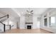 Living room features a fireplace with stone surround, hardwood floors, ceiling fan and large windows at 11338 Briargate Dr, Fishers, IN 46055