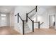 A stylish staircase featuring wood floors, white risers, black handrail, and neutral carpet on the treads at 11338 Briargate Dr, Fishers, IN 46055