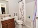 Well-lit bathroom featuring a single sink vanity, toilet, and a bathtub with shower and floral curtain at 1175 Bent Tree Way, Plainfield, IN 46168