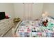 A bright bedroom features a cozy bed with a patterned quilt and light filtering curtains at 1175 Bent Tree Way, Plainfield, IN 46168
