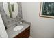 Stylish powder room with modern fixtures, vanity with granite countertop and designer wallpaper at 1175 Bent Tree Way, Plainfield, IN 46168