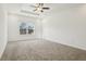 Bedroom features neutral walls, plush carpeting, tray ceiling, and a bright window with outdoor views at 122 Winding Brook Way, Pendleton, IN 46064