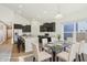 Dining area with a glass table and a view of the open-concept kitchen with dark cabinets at 122 Winding Brook Way, Pendleton, IN 46064