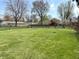 Large, expansive backyard with lush green grass, partially enclosed with a chain link fence at 1221 S Catherwood Ave, Indianapolis, IN 46203