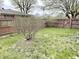 Fenced backyard showcasing a well-maintained lawn with a variety of trees and shrubbery at 1221 S Catherwood Ave, Indianapolis, IN 46203