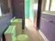 A purple bathroom with a green toilet and sink and worn-out flooring at 1221 S Catherwood Ave, Indianapolis, IN 46203