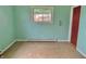 A simple bedroom with a green wall, window, and worn-out flooring at 1221 S Catherwood Ave, Indianapolis, IN 46203