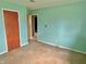 A spacious bedroom with mint green walls and worn-out flooring at 1221 S Catherwood Ave, Indianapolis, IN 46203