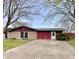 Inviting single-story home featuring a concrete driveway and a well-maintained front lawn with mature trees at 1221 S Catherwood Ave, Indianapolis, IN 46203