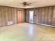 Living room with wood-paneled walls has glass door to backyard and storage closet at 1221 S Catherwood Ave, Indianapolis, IN 46203