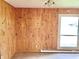 Wood-paneled living room with a large window and radiator, offering a rustic feel and natural light at 1221 S Catherwood Ave, Indianapolis, IN 46203