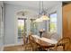 Bright dining room with backyard view through french doors, wood floors, and decorative chandelier at 12372 Ostara Ct, Fishers, IN 46037