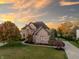 Beautiful brick home featuring an arched entryway, well-manicured lawn, long driveway, and basketball court at 12372 Ostara Ct, Fishers, IN 46037