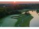 Sunrise aerial view of the golf course featuring manicured greens, sand traps, and a serene lake at 12372 Ostara Ct, Fishers, IN 46037