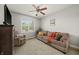 Bright living room featuring large windows, comfortable seating, and a ceiling fan at 12372 Ostara Ct, Fishers, IN 46037