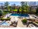 Aerial view showcasing the expansive backyard with a pool, hot tub, patios, and mature trees at 12715 Norfolk Ln, Carmel, IN 46032