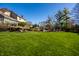 Expansive backyard featuring lush green lawn, mature trees, spacious deck, and inviting outdoor lounge area at 12715 Norfolk Ln, Carmel, IN 46032